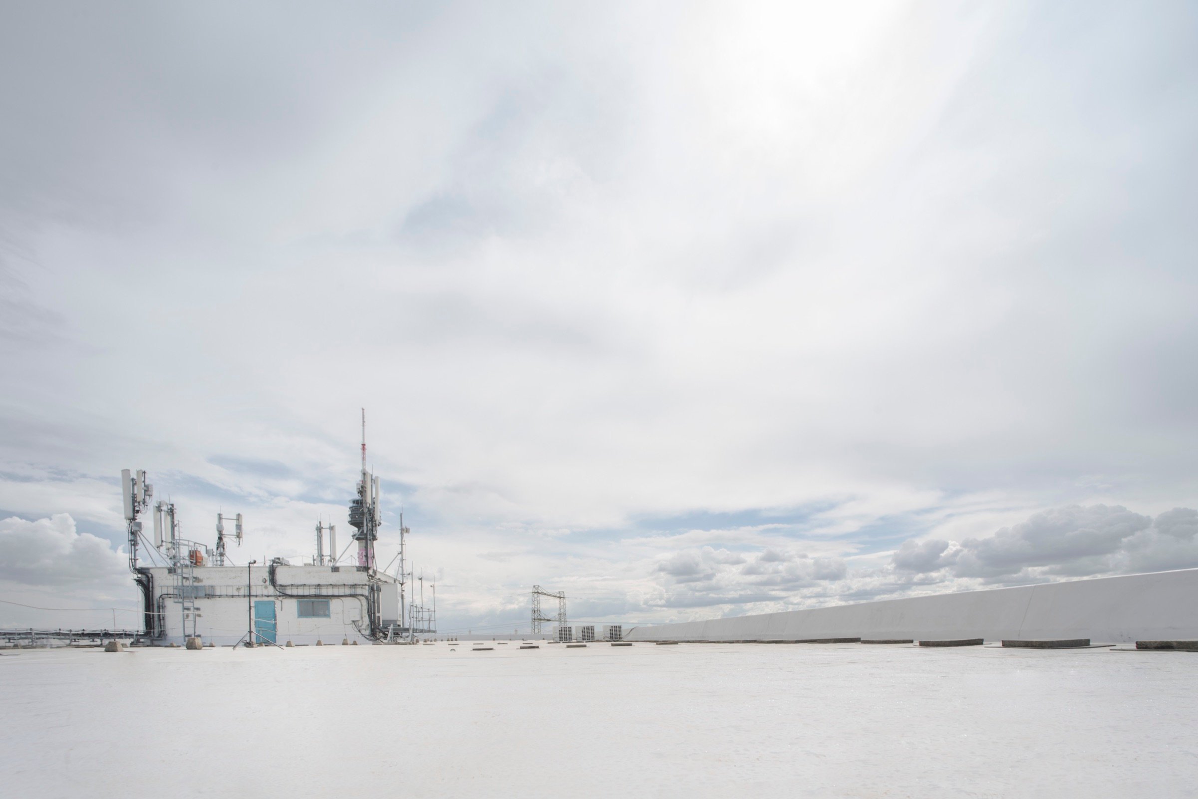 Picturepool Studios rooftop — cluster of telecom antenna equipment on a building structure, beneath a dramatic cloudy sky